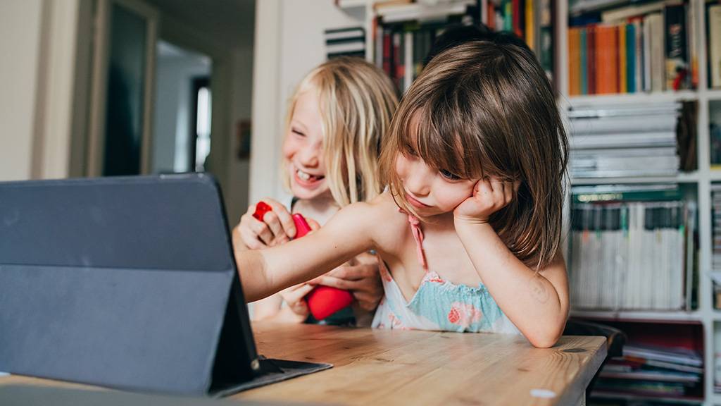 Duas meninas assistindo TV no tablet.